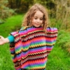 girl in poncho with arms outstretched