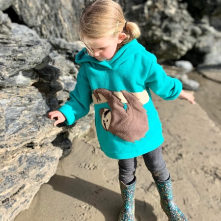 girl on the beach in sloth hoodie